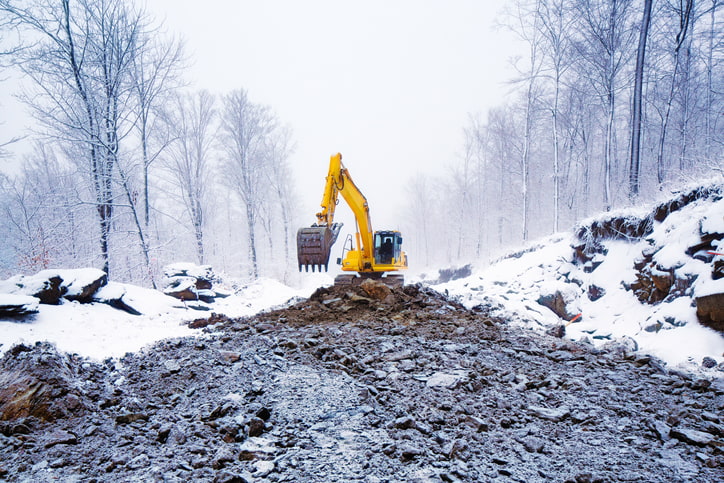 Excavator in a snowy forest